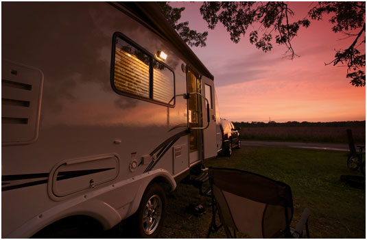 Side view of a luxury travel trailer in the sunset