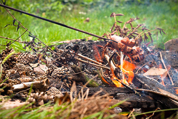 RV camper cooking over an open campfire