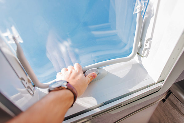 A person opening an RV vent lid